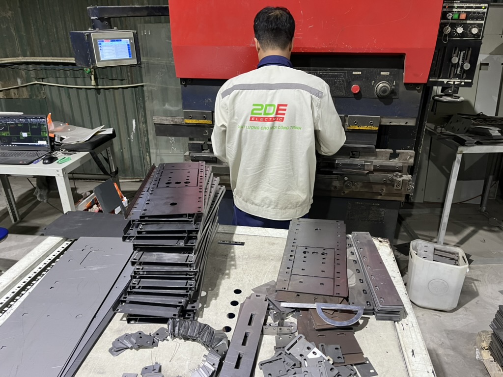 [Ảnh thực tế: máy cắt/đột lỗ CNC đang gia công tấm tôn tại xưởng 2DE]